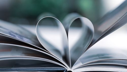 Uppslagen bok med sidovy med två sidor som formar ett hjärta